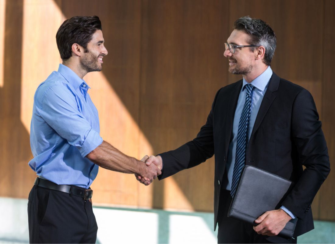 Two professionals shaking hands in a modern office setting